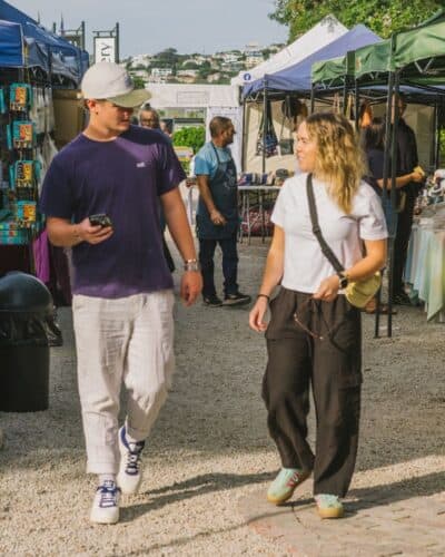 Two friends walking at the Wednesday Market at Old Nick Village